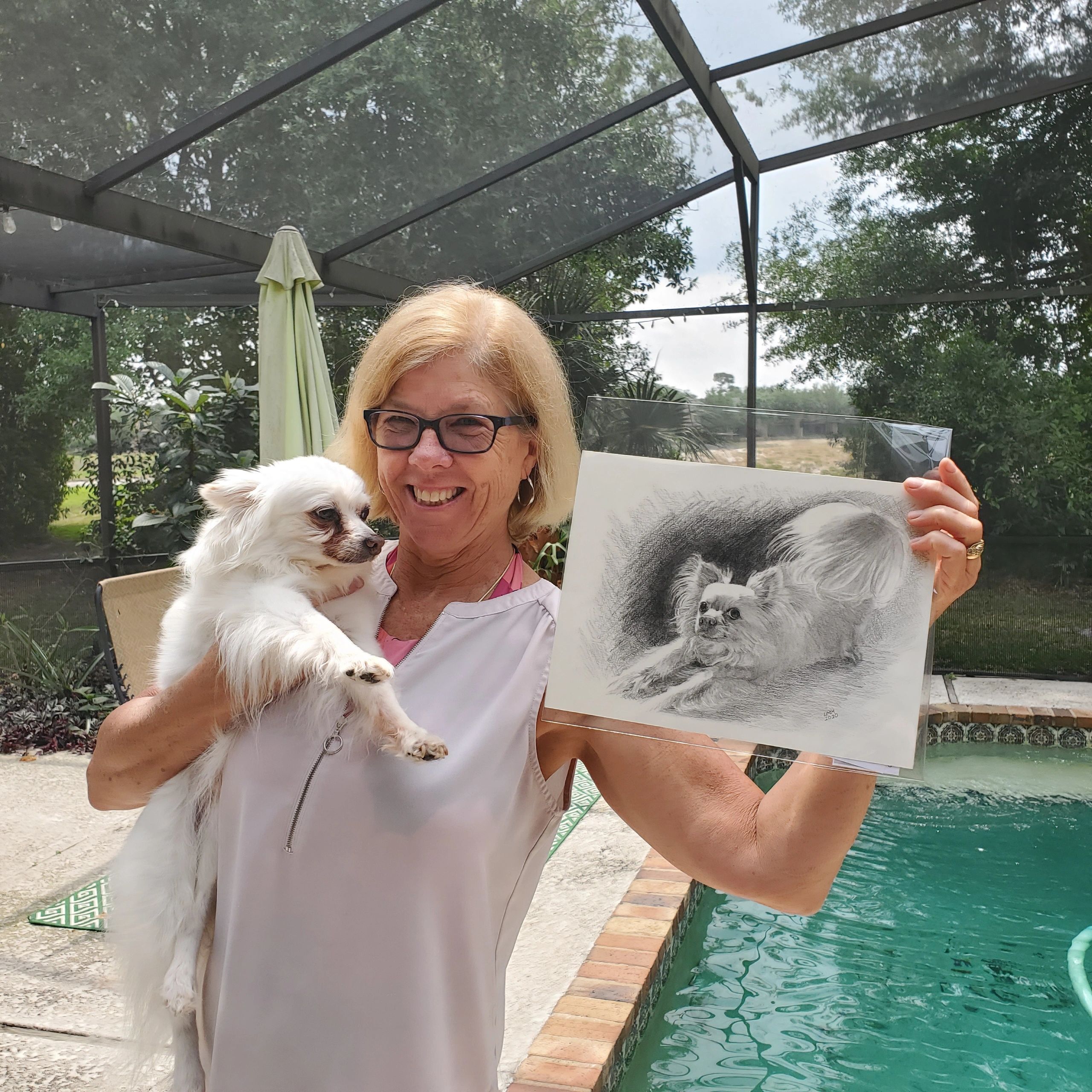 A woman holding her dog and a pet portrait done by Linda's Pet Portraits. Custom graphite portrait