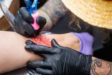 An artist giving a leg tattoo