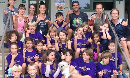 adults and a group of students wearing purple shirts