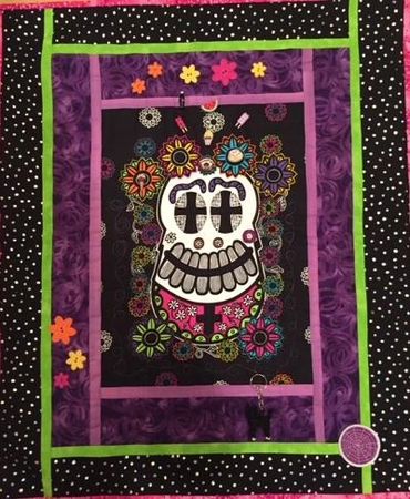 'Celebraciones II' This day of the dead fabric poster is embellished with flowers and charms, just a