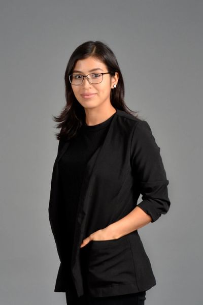 Young woman in glasses wearing a black blazer.