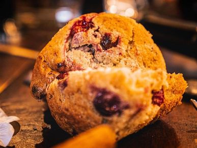 Close-up of a freshly baked berry muffin with a warm, cozy background.
