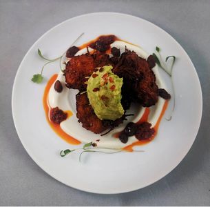 Harissa sweet potato fritters, labneh, smashed avo and pickled raisins