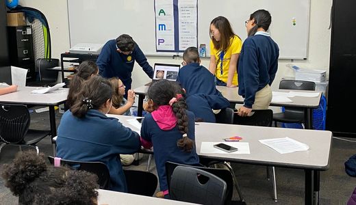 Annabelle shows students examples of artwork at the Boys and Girls Club.