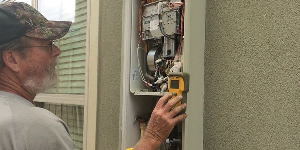 plumber checking for error codes in water heater