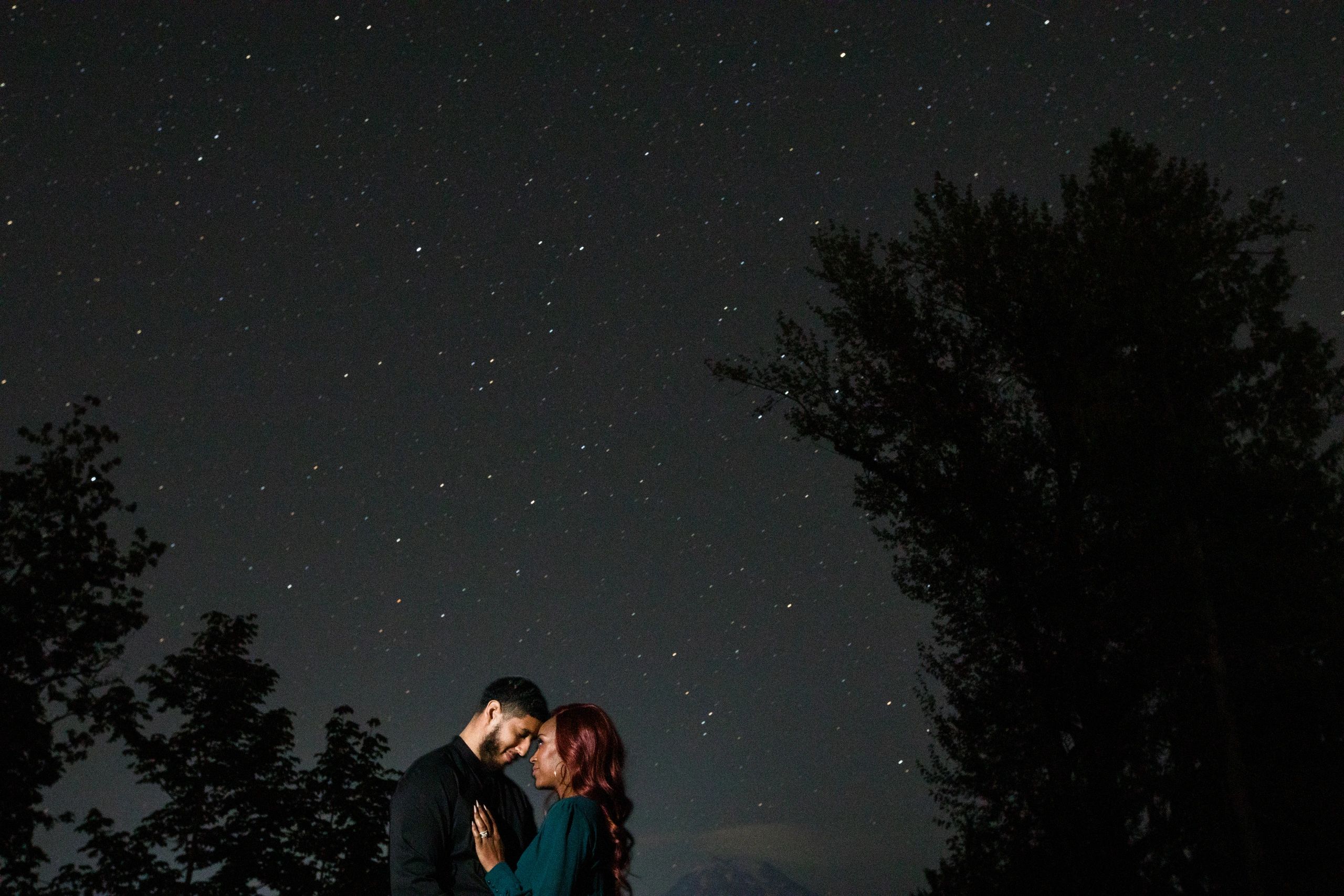 Beautiful woman holds a man under the stars.