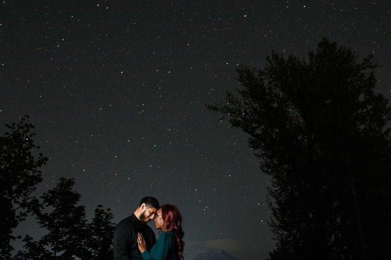 Beautiful woman holds a man under the stars.