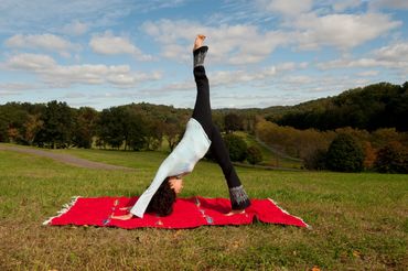 Downdog split yoga pose with sky and landscape, Rockefeller State Park, New York