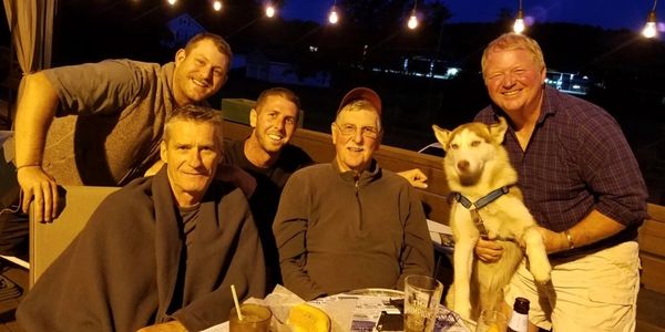 Group of people taking picture along with the dog