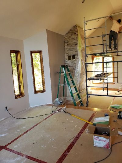 Travail de rénovation intérieure avec échafaudage et échelle.