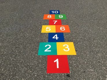 Colorful preformed thermoplastic Hopscotch numbered on old asphalt by Surface Signs Of NY