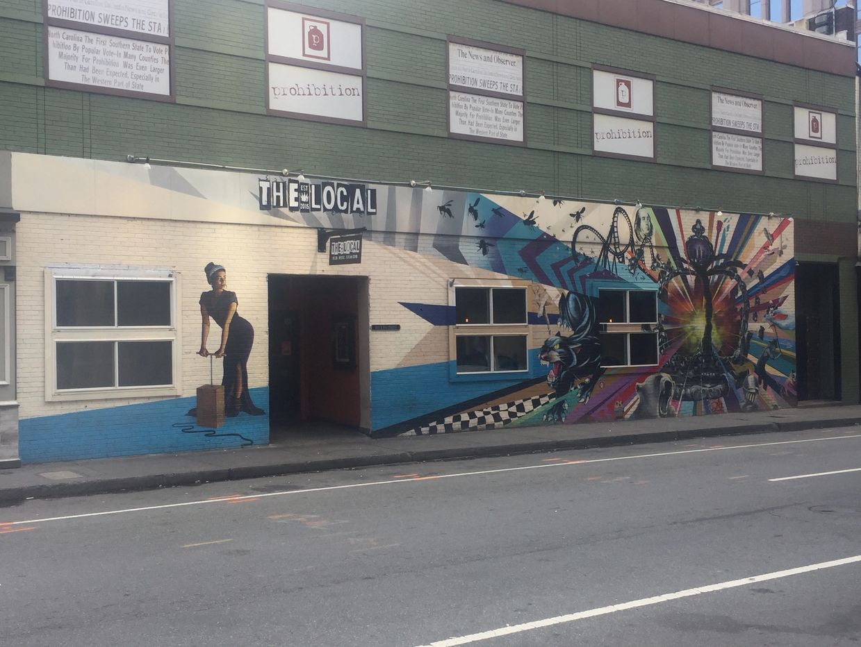 A mural with a vintage style girl pushing the pump to detonate a bomb of creativity and color.