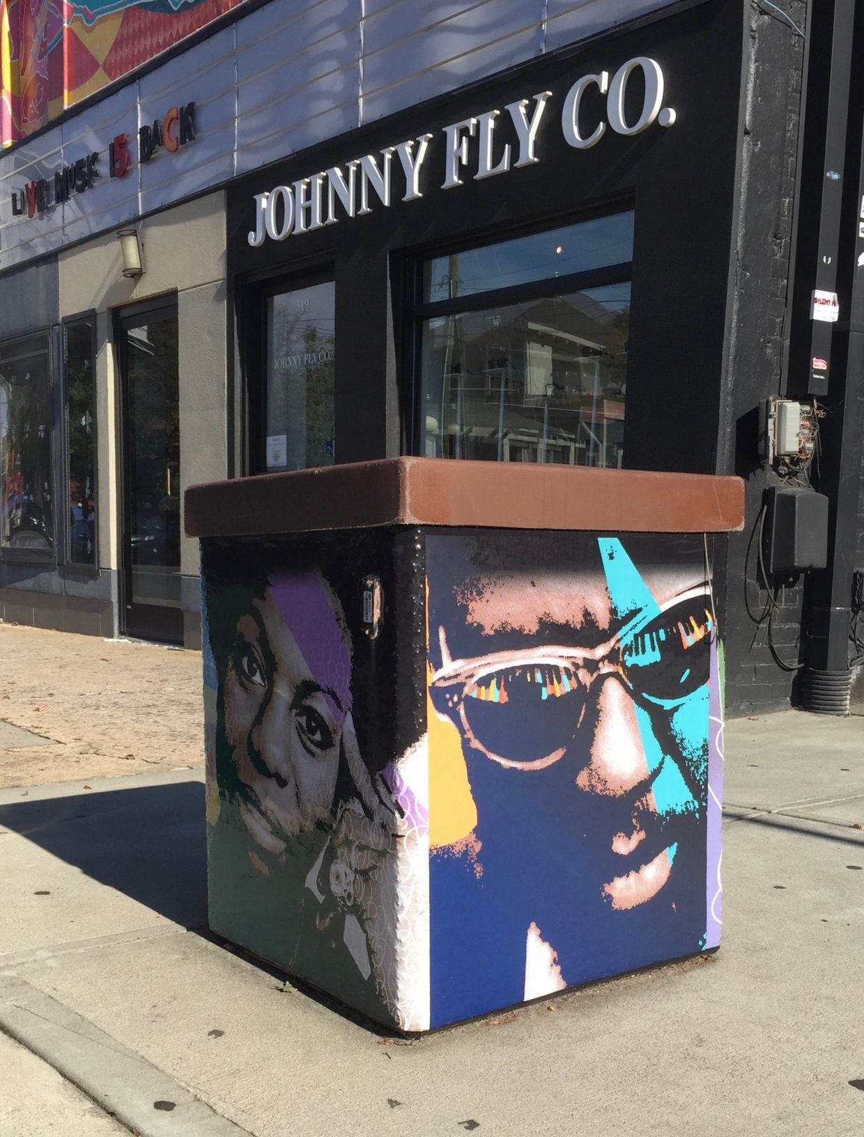 Large public trash can with vinyl wraps featuring famous portraits of African American musicians