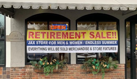 Outdoor retirement sale designed wide-format banner hung with grommet holes from a local print shop