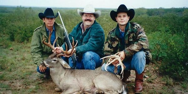 This is an image of three men with a hunted whitetail deer.