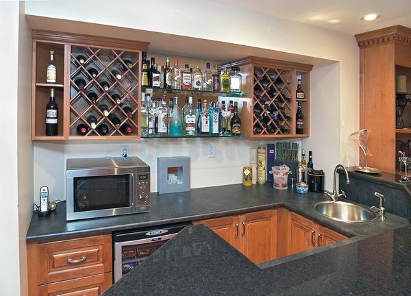 Basement bar with wine rack and wet bar, black granite counter tops, microwave on the counter