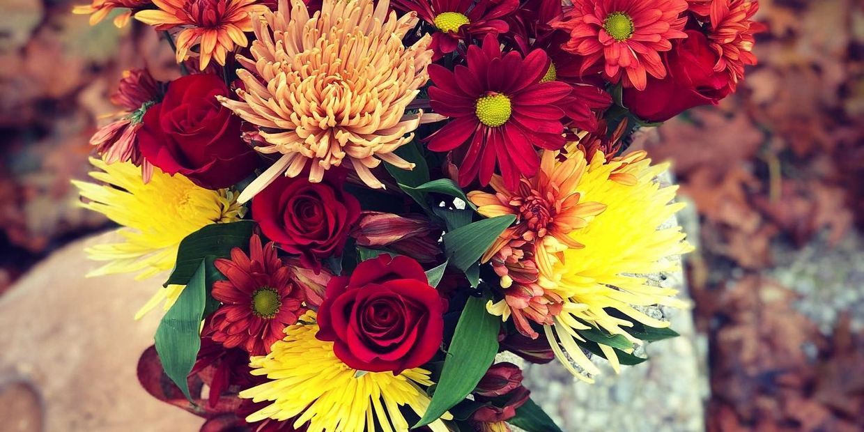 Fall arrangement with mums, roses and daisies.
