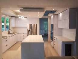 Cocina blanca en PVC a la medida con cascadas cuarzo. Construida en Puerto Rico.