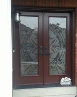 chestnut brown double entry doors with wrought iron.