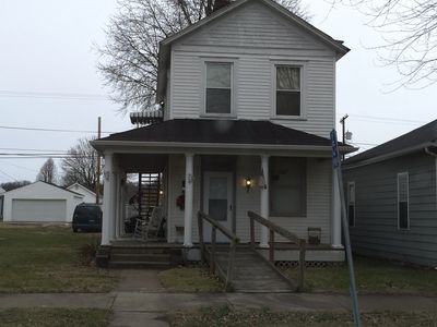 A two-story house with a front porch and a wheelchair ramp.