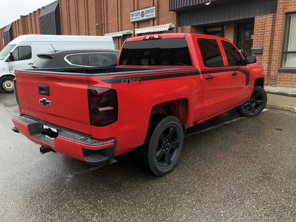 Red pickup truck with window tint in Toronto
