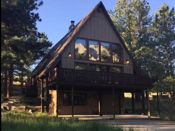 A-frame cabin with reflection view of the Chalk Cliffs in window on a summers day