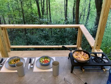 Sitting down to a hot meal in the outdoor kitchenette at treehouse #1 in July