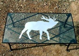 Custom built coffee table.  Steel frame, glass top with an elk inlayed in mirror.
