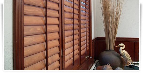 Custom Wood shutters in living room home in Nebraska. Stained wood shutters to match home.