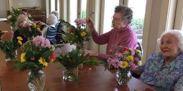 Nursing home residents making flower arrangements during garden therapy