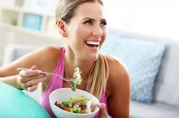 Happy fit woman eating healthy food