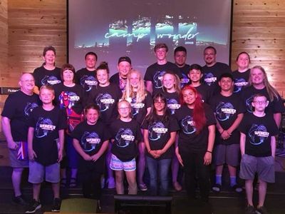 Group photo of camp attendees wearing matching shirts.