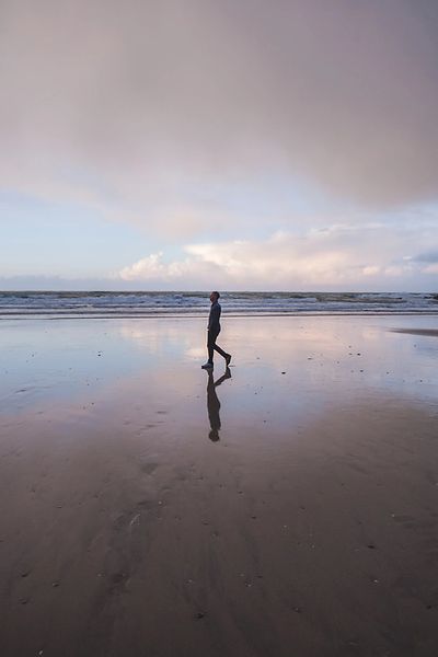 Zac Fine walking on a beach
