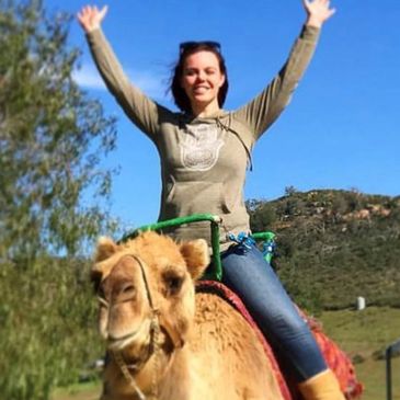 Young lady riding a smiling camel