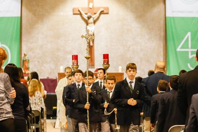 Boys in suits participating in a religious procession inside a church.