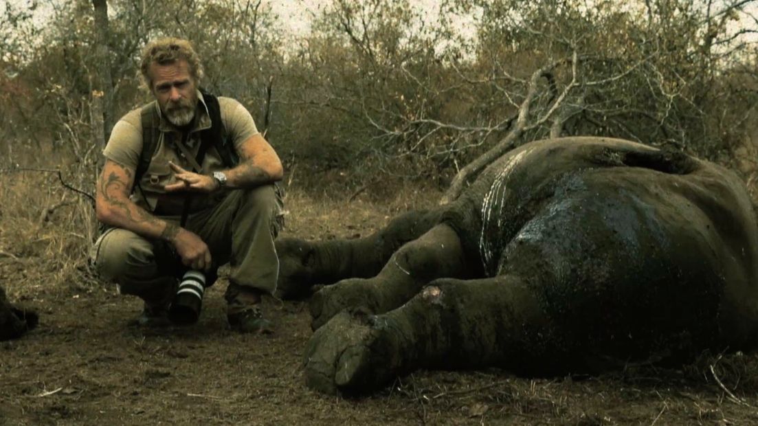 director steven lyon standing next to a poached rhino while making something that matters film