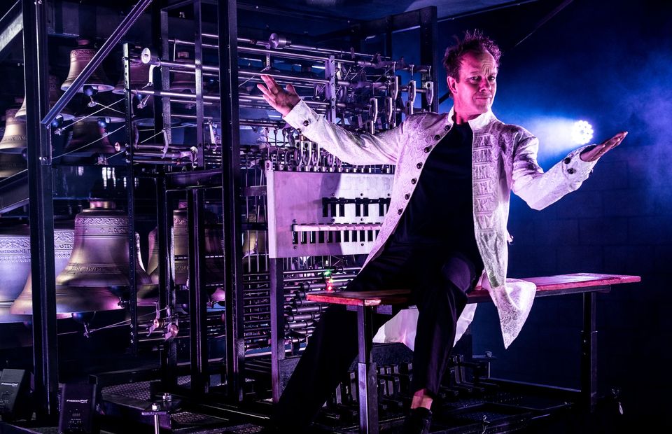 Charlie sitting  on the bench of the carillon with his arms wide open as if to invite you to his mag