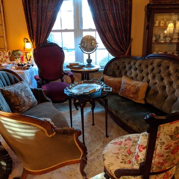 Vintage living room with antique furniture and decorative items.