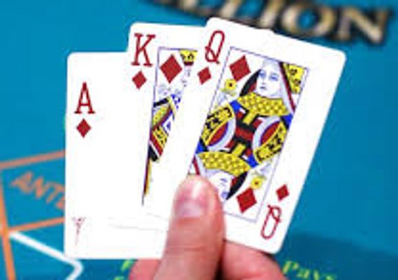 MANS HAND HOLDING 3 CARD POKER HAND ACE KING QUEEN