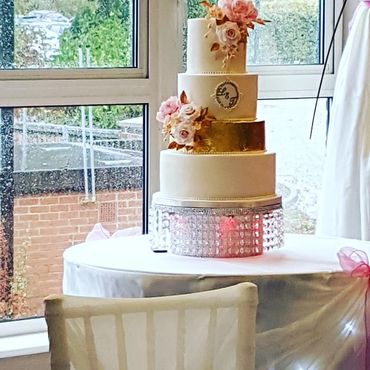 4 tier wedding cake with blush and white roses and with edible 24K gold leaf. Classic wedding c