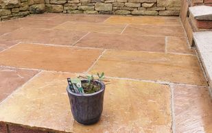 A very clean looking patio, with a plant pot.