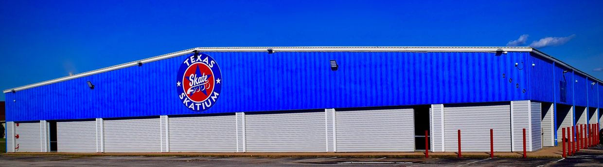 Exterior view of Texas Skatium building under clear blue sky.