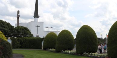 Church with trimmed bushes and green lawn.