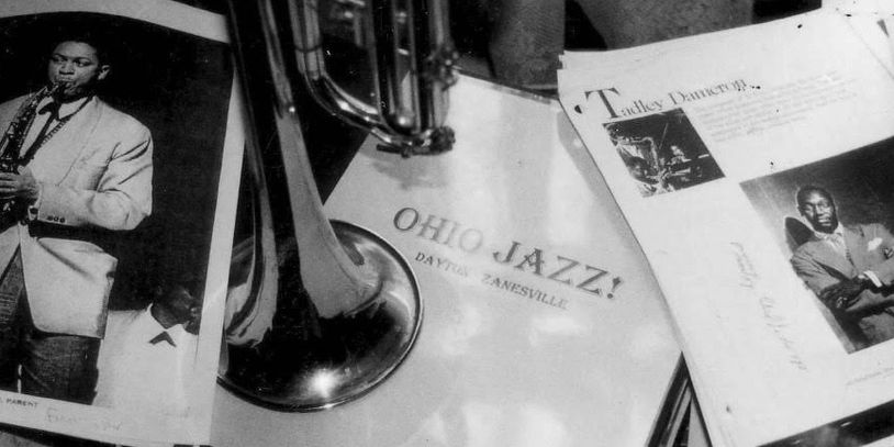 Vintage jazz memorabilia with a trumpet and black-and-white photos.