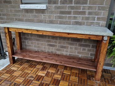 STAINED CEDAR TABLE BASE WITH A 
2" THICK CAST CEMENT TOP