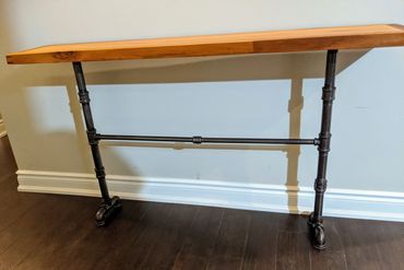 OAK SLAB BANDED WITH SAPELE AND TIGER WOOD WITH EBONY CORNER SPLINES ATOP OF AN CAST IRON PIPE LEGS