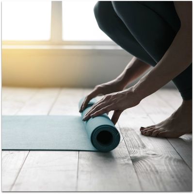 Yoga student rolling up her mat