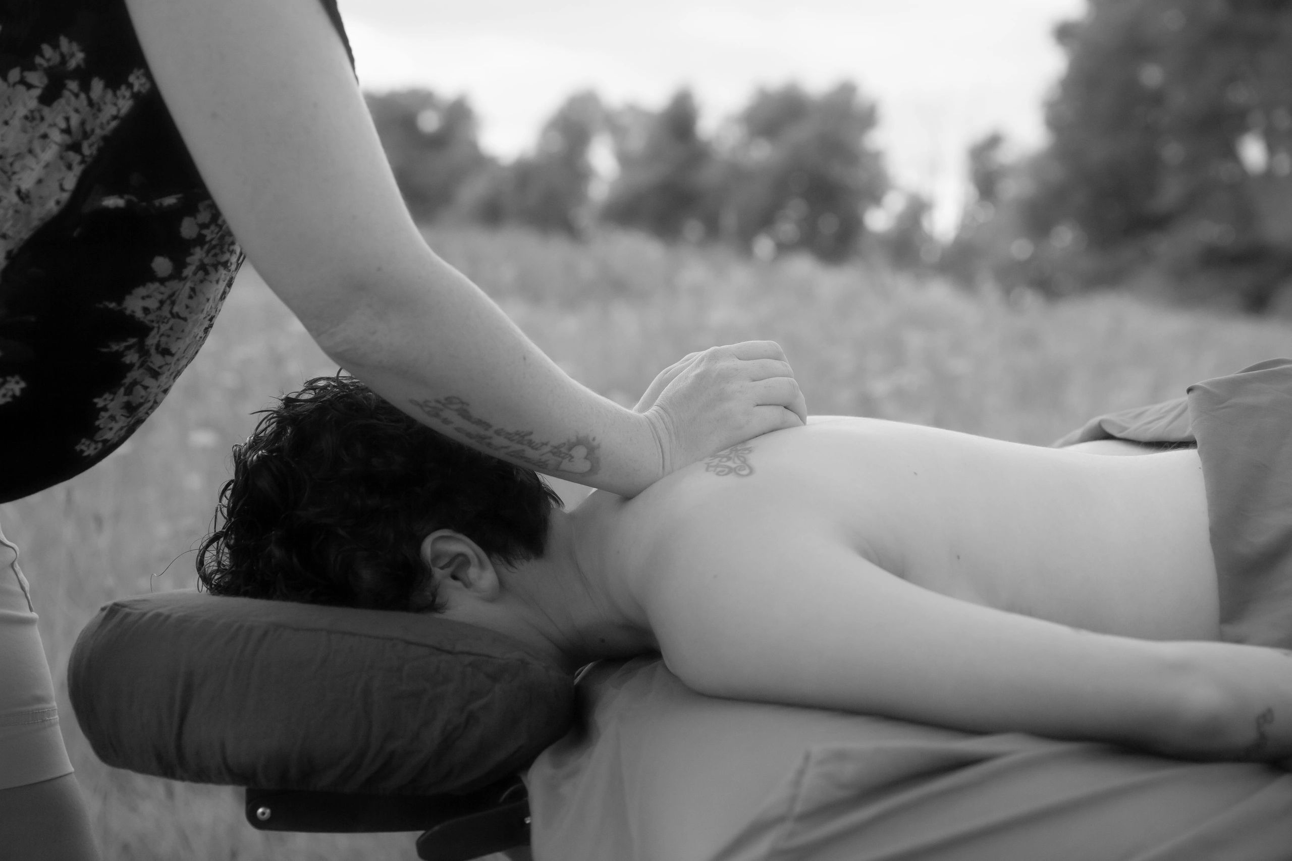 B&W image, woman face down on massage table getting a massage