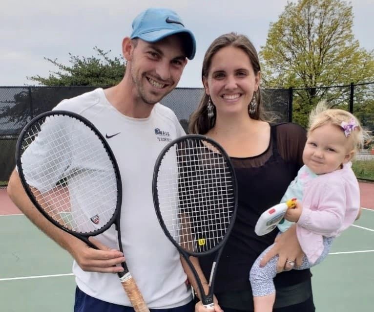 Coach Paul with his wife and daughter holding tennis racquets