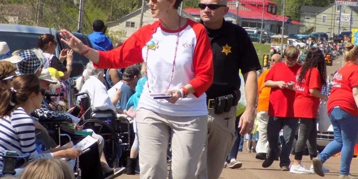 People participating in a parade with a security officer present.